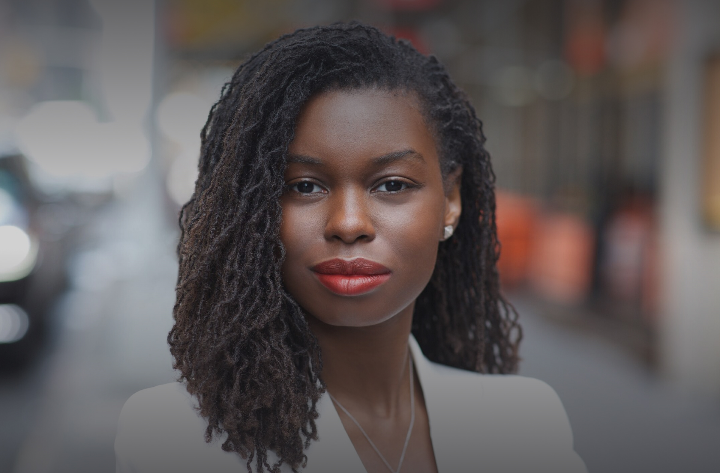 Outdoor headshot NYC — woman on a city street with blurred traffic background