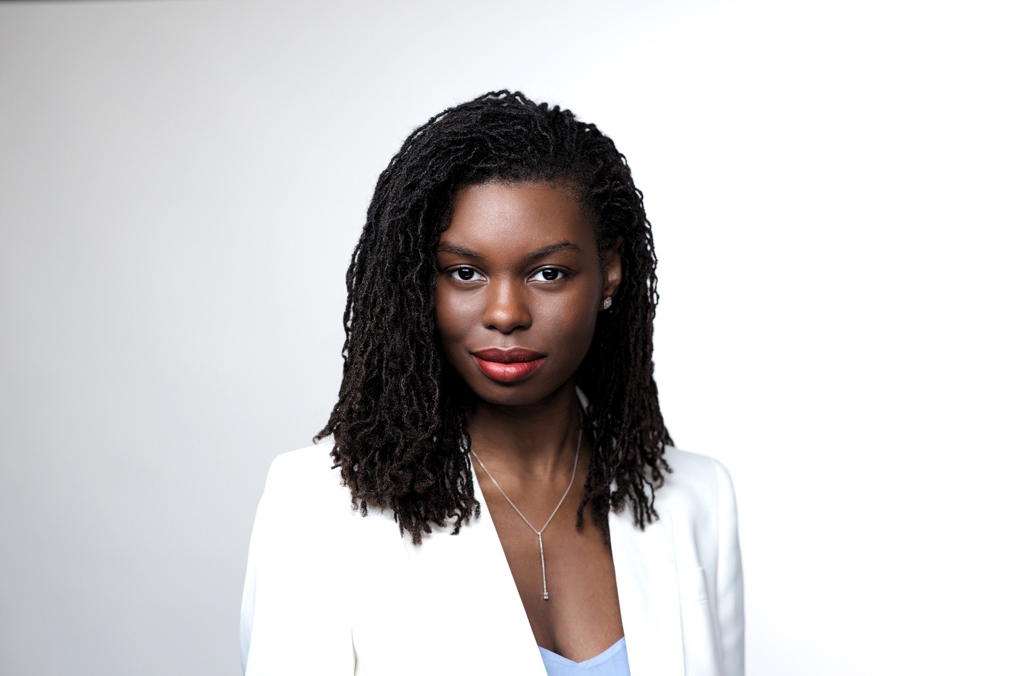 Business headshot NYC — woman in white blazer, light studio backdrop